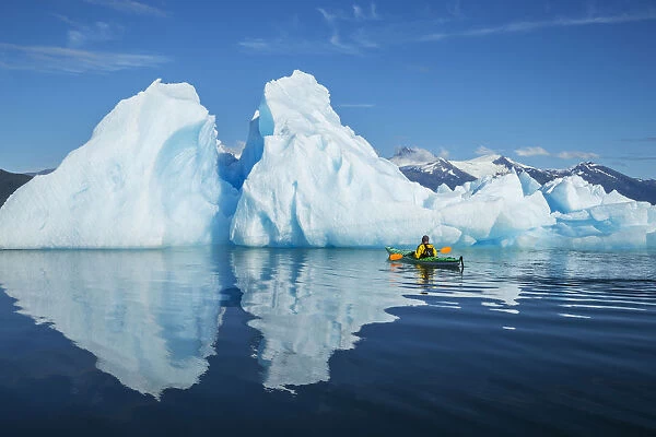 A Sea Kayaker Paddles Beside An Iceberg In Southeast Alaskas Stephens Passage On A Summer Evening, Holkham Bay, Tracy Arm. Mr_ Ed Emswiler, Id#: 12172012A