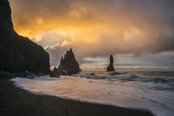The Sea Stacks Known As Reynisdrangar With Waves At Sunrise, South Coast; Iceland