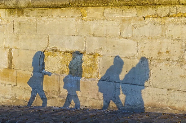 Shadows Of Pedestrians Cast On A Wall; Paris, France