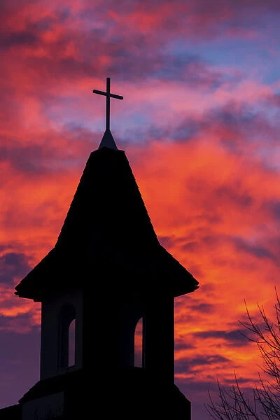 Silhouette Of A Church Steeple With Colourful Clouds And Blue Sky In The Background; Calgary, Alberta, Canada