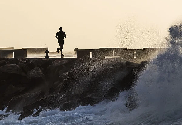Silhouette Of A Man Running Along The Coast; La Isla, Tarifa, Cadiz, Andalusia, Spain