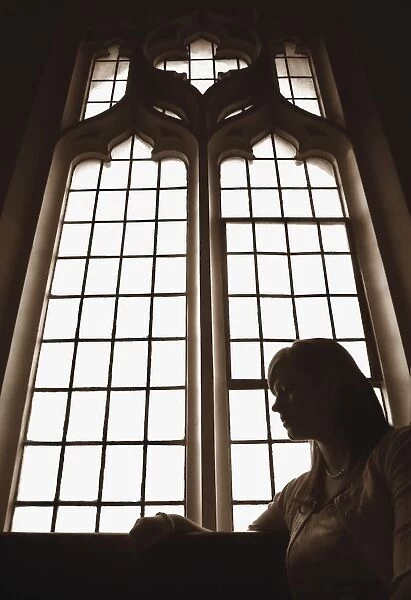 Silhouette Of Woman In Front Of Church Window