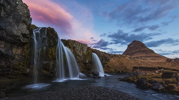 Small Waterfall With Kirkjufell In The Distance And Clouds Lit By The Rising Sun; Snaefellsnes Peninsula, Iceland