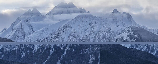 Snow covered majestic mountains with misty clouds hovering at the peaks, Haines, Alaska, USA