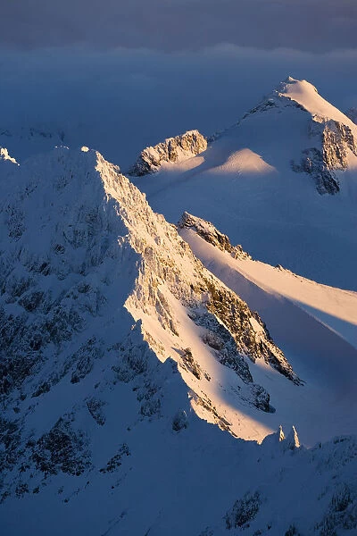 A Snow Covered Mountain Covered By Shadows And Sunlight, Kachemak Bay State Park; Alaska, United States Of America
