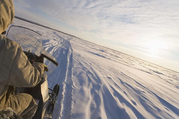 Snowmachiner Following Trail On Frozen Snow Covered Kuskokwim River Western Alaska Winter