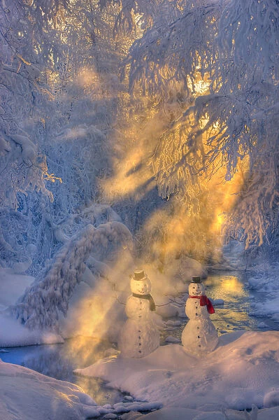 Snowman Couple Standing Next To A Stream With Sunrays Shining Through Fog And Hoar Frosted Trees In The Background, Russian Jack Springs Park, Anchorage, Southcentral Alaska, Winter. Digitally Enhanced