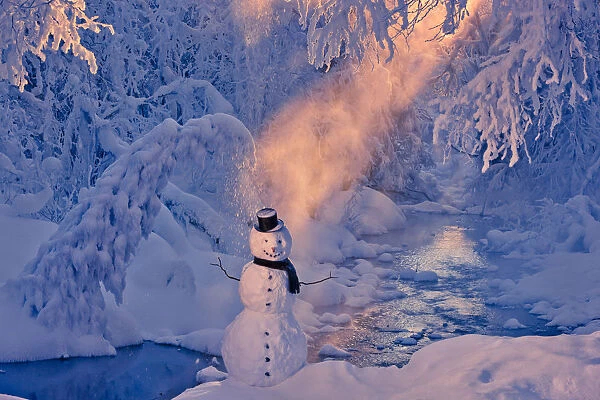 Snowman Standing Next To A Stream With Sunrays Shining Through Fog And Hoar Frosted Trees In The Background, Russian Jack Springs Park, Anchorage, Southcentral Alaska, Winter. Digitally Enhanced