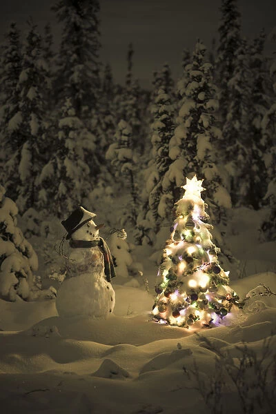 Snowman Stands In A Snowcovered Spruce Forest Next To A Decorated Christmas Tree In Wintertime