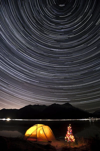 Star Trails Circle Above The Chugach Mountains With A Backpacking Tent And Christmas Tree Along The Shore Of Turnagain Arm, Southcentral, Alaska, Winter