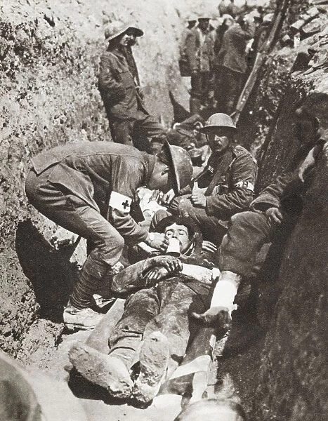 Stretcher Bearers Giving Aid To A Soldier Lying Wounded In A Trench On The Somme, France During World War I. From The Story Of 25 Eventful Years In Pictures, Published 1935