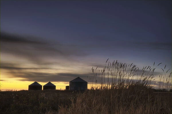 Sunset Silhouetting Grain Silos In Autumn, Rural Alberta