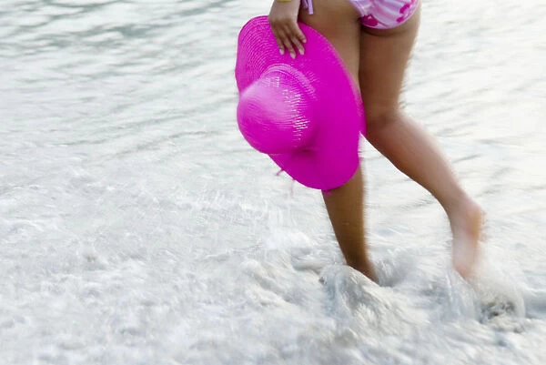 Thailand, Phuket, Kata Noi, Blurred Action Shot Of Womans Legs Walking Through Water Holding Hat