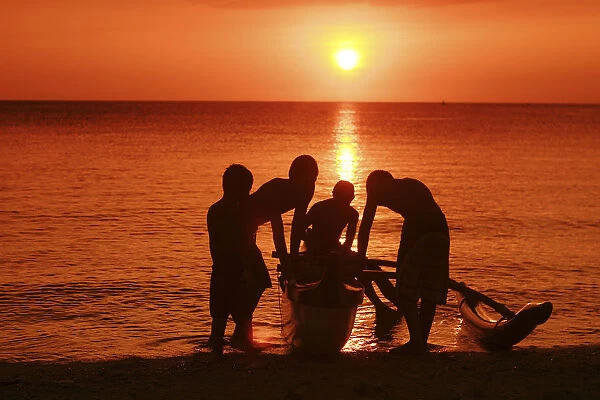 USA, Hawaii, Oahu, Boys holding canoe at sunset; North Shore