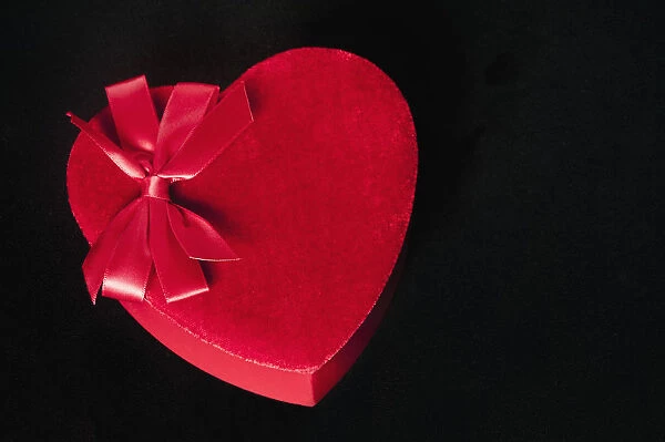 Valentines heart-shaped candy box against black background