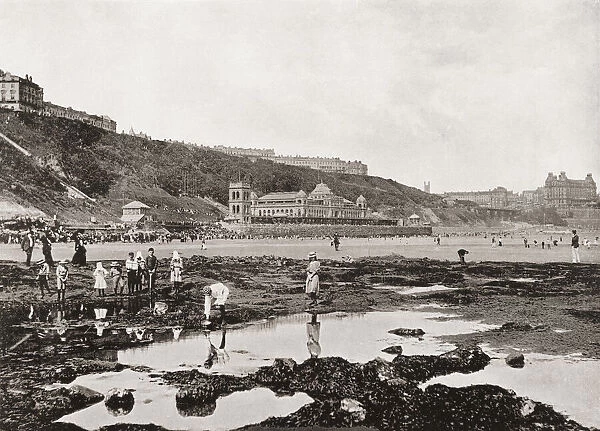 View from the rocks of South Bay and the Spa, Scarborough, North Yorkshire, England, seen here in the 19th century. From Around The Coast, An Album of Pictures from Photographs of the Chief Seaside Places of Interest in Great Britain and Ireland published London, 1895, by George Newnes Limited