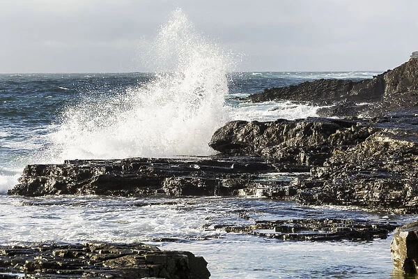 Wave Crashing Into Rocky Coast With Cloudy Sky; Kilkee, County Clare, Ireland