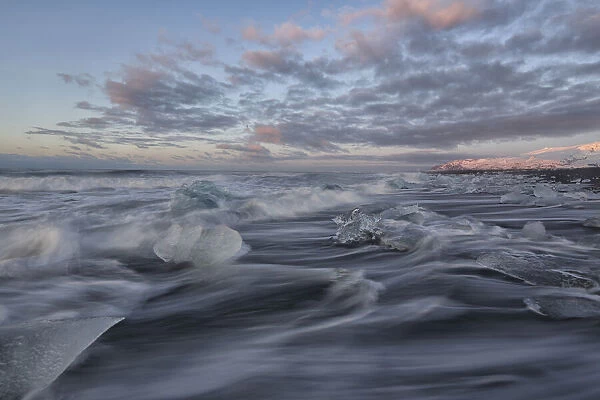 Waves of the atlantic ocean break over icebergs outside the glacial lagoon jokulsarlon; iceland