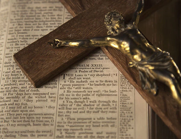 Wooden crucifix laying on open Bible; Yetholm, Scottish Borders, Scotland, UK