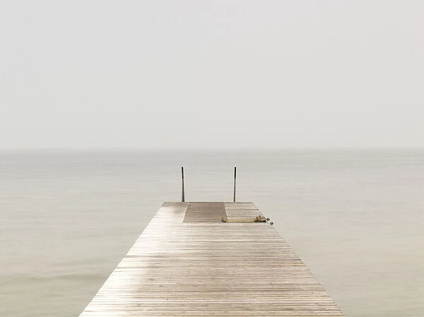 Wooden Pier On Misty Lake At Dawn