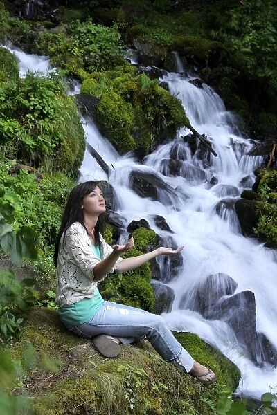 Young Girl Worshipping Beside Waterfall