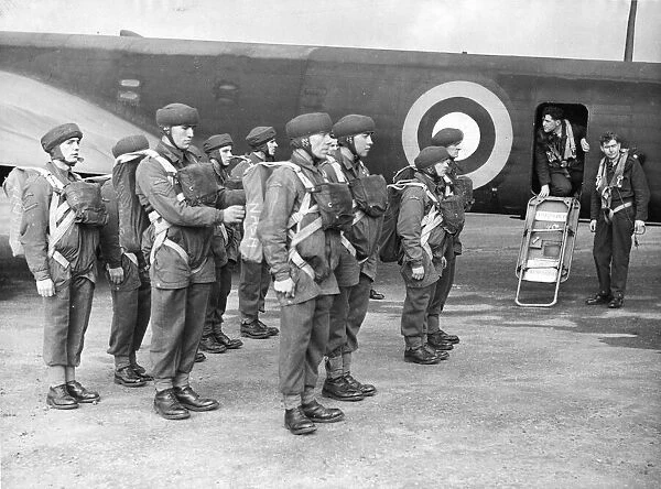 The corporal inspecting the parachute equipment of British parachutists before they enter