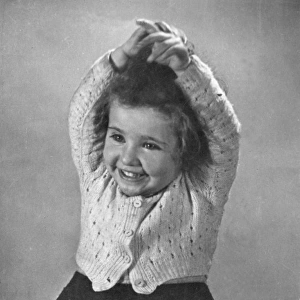 Happy little girl in a knitted cardigan