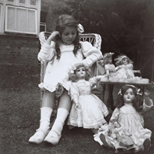 Little girl with dolls in a back garden