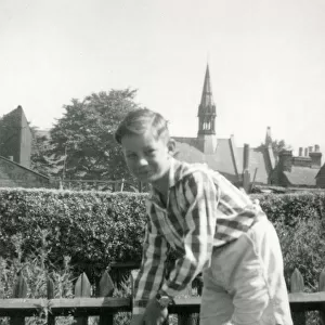 A Young boy playing cricket in a suburban garden - he awaits for a delivery to arrive