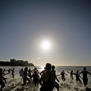 People running into the sea