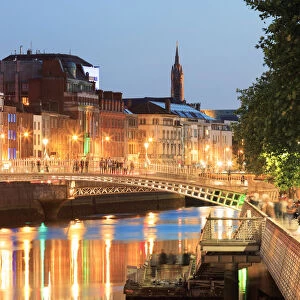 Europe, Dublin, Ireland, Halfpenny bridge by night reflecting on the Liffey river