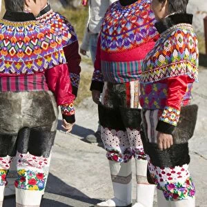 Inuit women wearing traditional Greenlandic national costume or Kalaallisuut in Ilulissat on Greenland. The costume consists of seal skin boots(Unnaat) bead necklaces (Nuilaqutit) and seal skin trousers