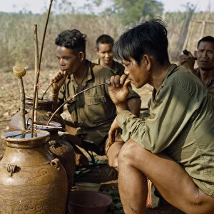 VIETNAM Vietnam War. Montagnard men drinking rice wine