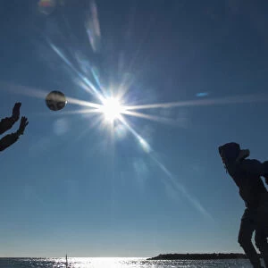 Tourists play with a ball on the beach on a sunny day at Valras-Plage