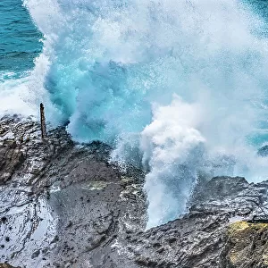 Halona Blowhole Lookout, Oahu, Hawaii. Waves roll in rock formation shoots sea spray in the air