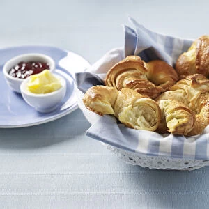 Basket of croissants, butter and jam