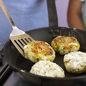 Cooking fishcakes in frying pan, close-up