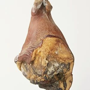 Dried cooked ham on hook