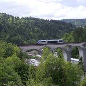 France, Franche-Comte, Ligne des Hirondelles, train crossing railway viaduct in the French Jura, near Morez