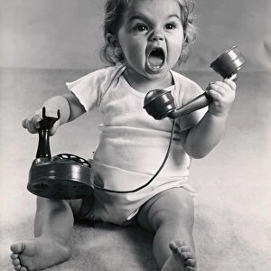 Vintage photo of infant screaming with phone