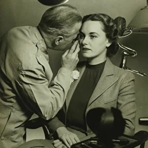 Optician examining womans eye, (B&W)