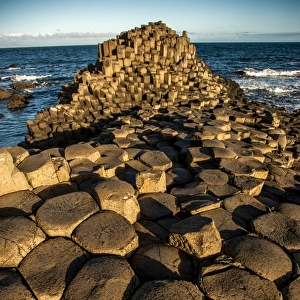 The rising sun on a rock formation called the Giants Causeway, County Antrim, Northern Ireland