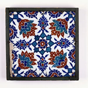 An Iznik pottery tile, with a symmetrical design of four red