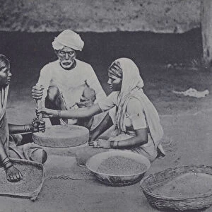 Man and women grinding corn, North Africa (b / w photo)