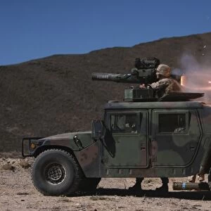A missileman firing a BGM-71 TOW missile atop a humvee