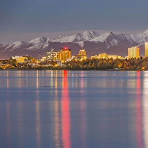 The Anchorage Skyline With The City Lights Reflected In The Water Of Knik Arm At High Tide, Snow Covered Chugach Mountain In The Background, Knik Arm, Cook Inlet, Anchorage Southcentral Alaska, Usa