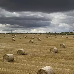 Dark Storm Clouds Over A Field With Hay Bales; South Shields, England