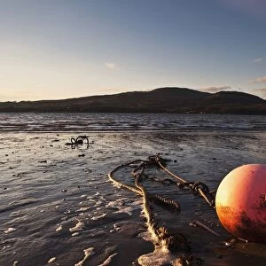 Dumfries, Scotland; A Rope Tied To A Buoy Laying In The Tide On The Shore