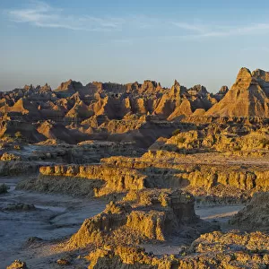 The eroded formations of badlands national park light up at sunrise from the window and door trail; south dakota united states of america