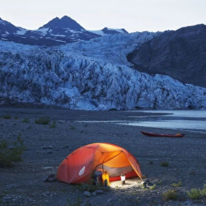Glowing Tent And Kayak On The Beach In Front Of Shoup Glacier And Mountains At Dusk, Shoup Bay State Marine Park, Prince William Sound, Valdez, Southcentral Alaska